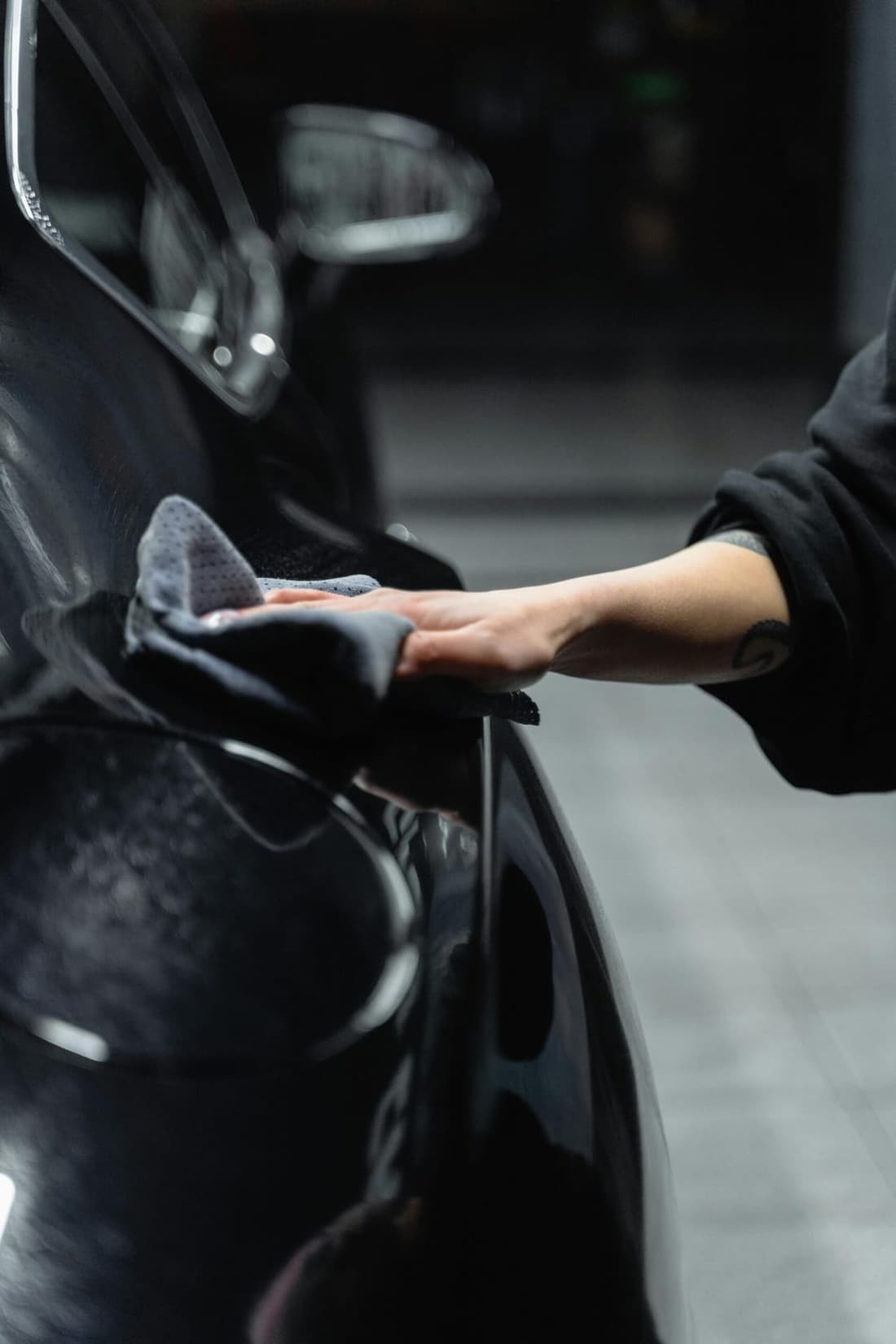 "Premier Autos Detailing expert hand-wiping the exterior of a car under the window, highlighting our meticulous mobile detailing services in West Plains, MO."