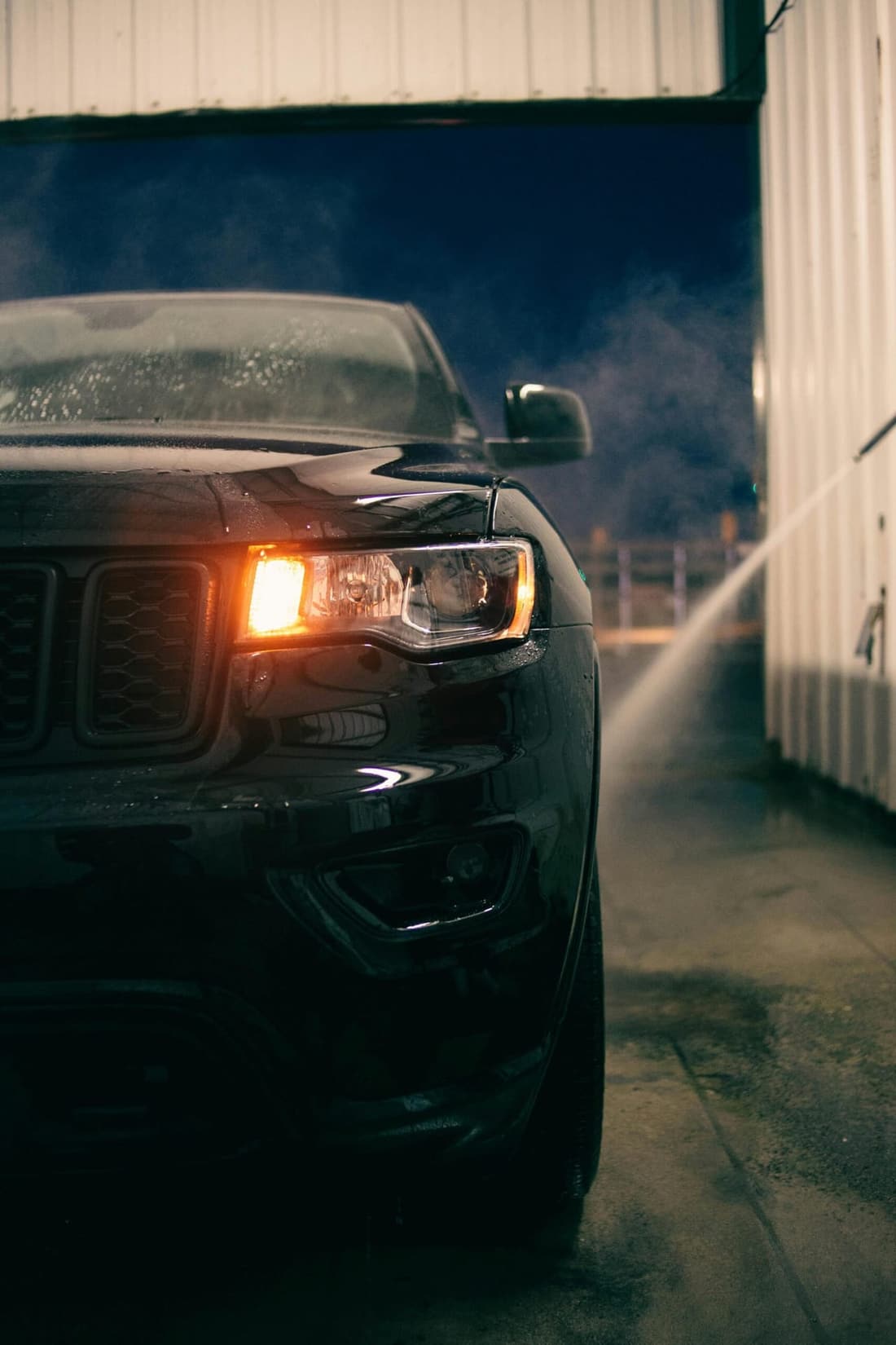 Black SUV being professionally washed at night at Premier Autos Detailing in West Plains, MO.