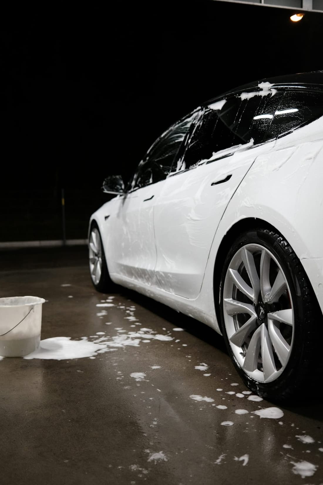 "Professional car detailing in West Plains, MO: Bottom side view of a car covered in car shampoo by Premier Autos Detailing, showcasing expert car cleaning services to avoid common mistakes."