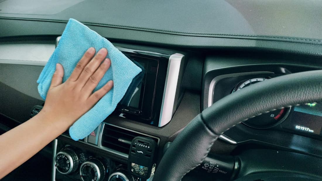 Premier Autos Detailing team cleaning car dashboard with blue microfiber towel