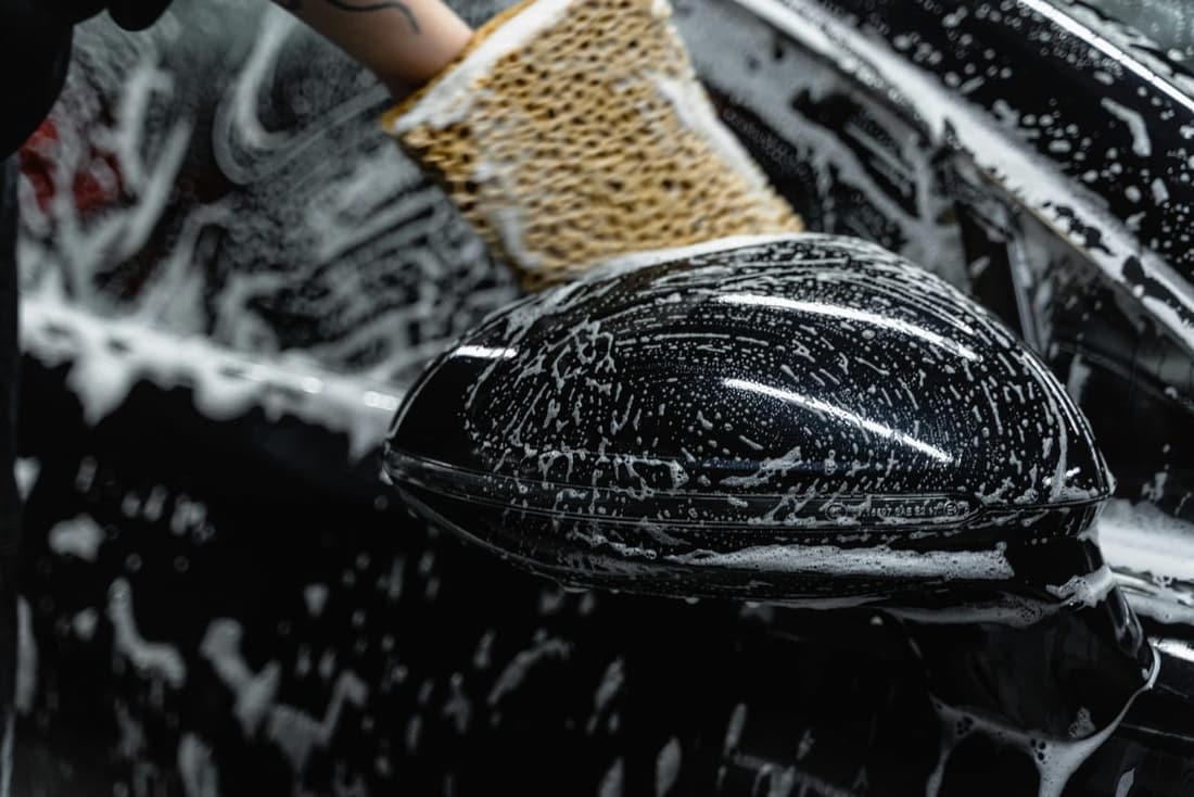 "Black car covered in rich car shampoo during a professional wash, showcasing meticulous attention to detail by Premier Autos Detailing in West Plains, MO."