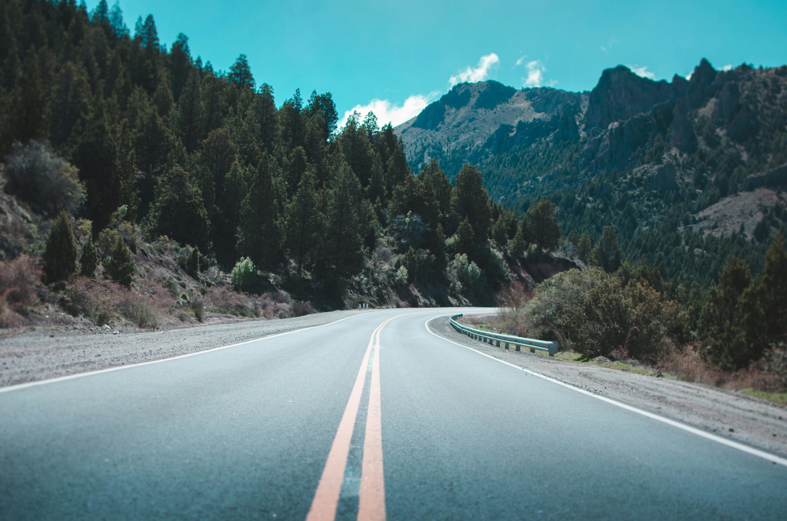 "Scenic road view captured during a road trip, showcasing a spotless vehicle after a professional detail by Premier Autos Detailing. The clean windows and polished exterior highlight the benefits of expert care for a safe and enjoyable journey."