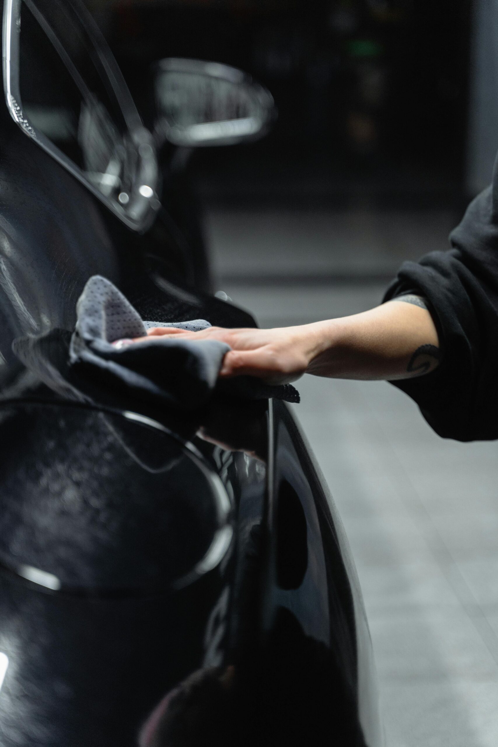 pexels-tima-miroshnichenko-6872572 "Premier Autos Detailing expert hand-wiping the exterior of a car under the window, highlighting our meticulous mobile detailing services in West Plains, MO."