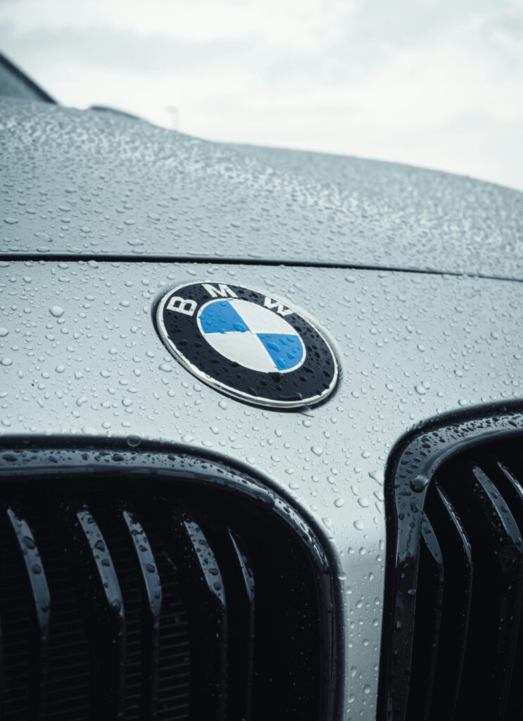 Close-up of a freshly detailed BMW hood and grille with water beading on the surface, showing premium car detailing results by Premier Autos Detailing in West Plains, MO.