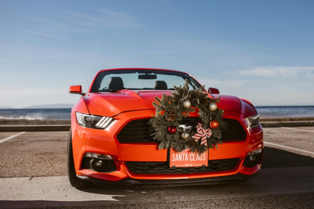 Red Ford Mustang with a Christmas wreath on the grille and a “Santa Clause” license plate, freshly detailed by Premier Autos Detailing in West Plains, MO.